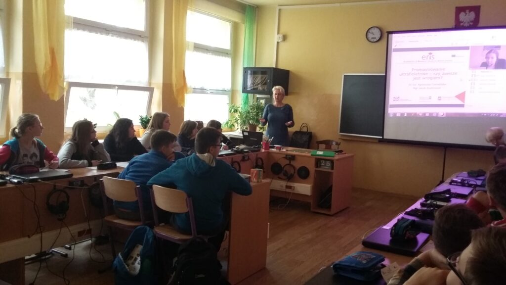 Zajęcia w sali dydaktycznej - uczniowie siedzą w ławkach a nauczycielka prowadzi wykład